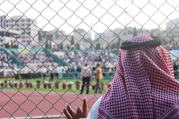 والد أحد الطلبة يشاهد حفل التخريج من خلف سور الجامعة الأردنية