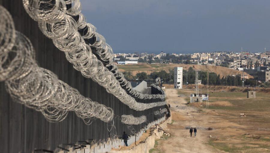 نازحون فلسطينيون يسيرون بجوار السياج الحدودي بين غزة ومصر في رفح، جنوب قطاع غزة 16/2/2024 | المصدر: وكالة الأنباء الفرنسية