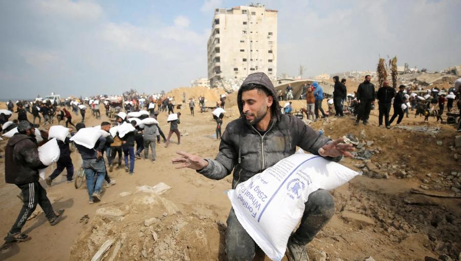 رجل فلسطيني من غزة يحصل على كيس طحين وسط المجاعة التي يعيشها القطاع | المصدر: الجزيرة