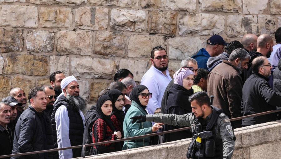 أحد أفراد شرطة الاحتلال الإسرائيلي يقيد مرور المصلين الذين يريدون أداء صلاة الجمعة في المسجد الأقصى عبر نقطة تفتيش بالقرب من باب الأسباط | المصدر: الشرق الأوسط