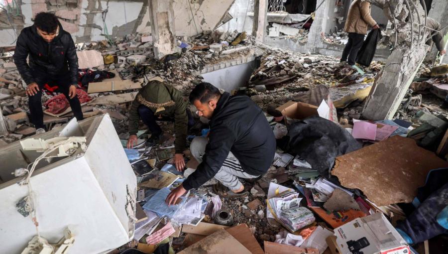 فلسطينيون يبحثون بين أنقاض وحطام مبنى قصفه الاحتلال الإسرائيلي في رفح جنوب قطاع غزة | المصدر: وكالة الأنباء الفرنسية