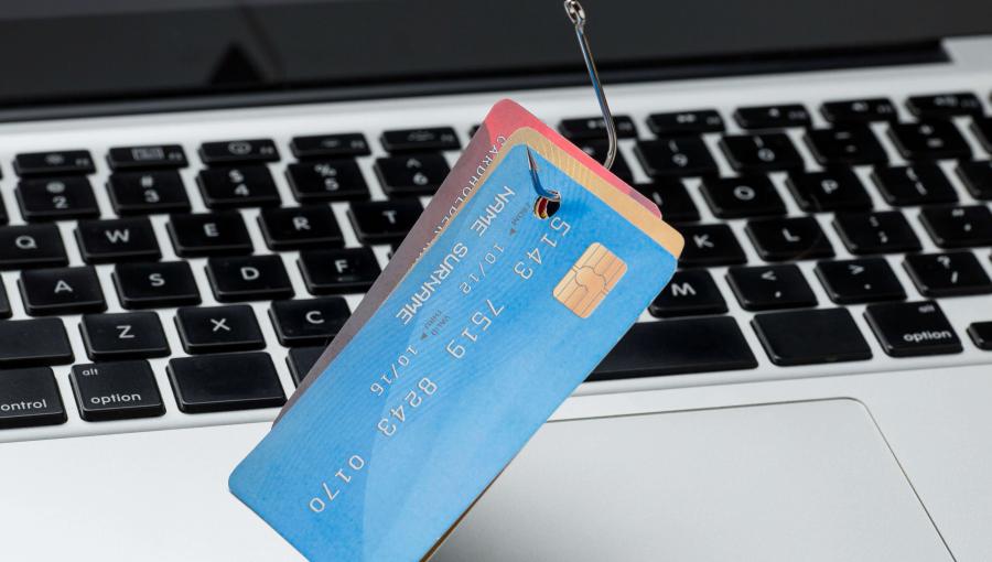 بطاقات بنكية مثقوبة فوق جهاز حاسوب | المصدر: freepik