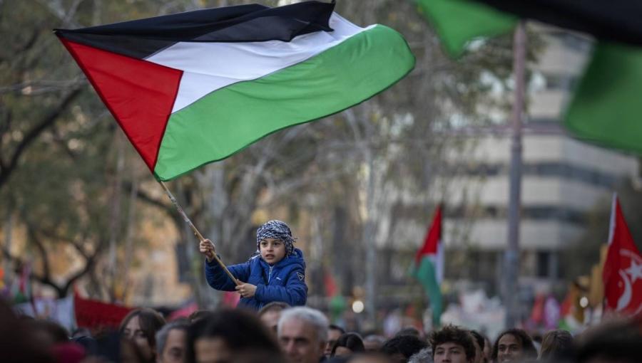 صبي يلوح بالعلم الفلسطيني في برشلونة صبي يلوح بالعلم الفلسطيني في برشلونة وحوله متظاهرون يطالبون بوقف فوري لإطلاق النار في غزة | المصدر: أسوشييتد برس
