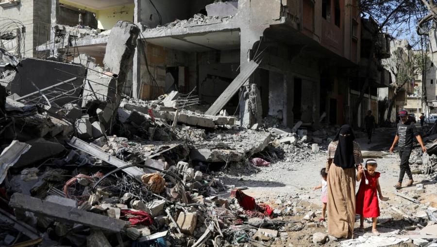 طفلة فلسطينية مع والدتها قرب الدمار التي سببه قصف الاحتلال على مخيم النصيرات وسط قطاع غزة | المصدر: رويترز