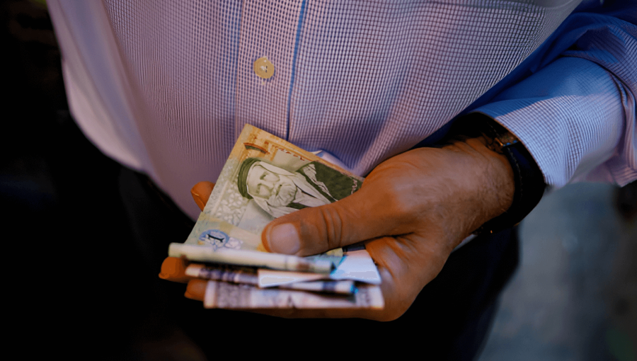 رجل يحمل نقودا أردنية | المصدر: Getty Images