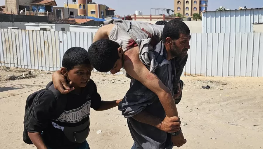 فلسطيني يحمل رجلا أصيب في أثناء وقوفه في طابور للحصول على مساعدات فلسطيني يحمل رجلا أصيب في أثناء وقوفه في طابور للحصول على مساعدات | المصدر: وكالة الأنباء الفرنسية