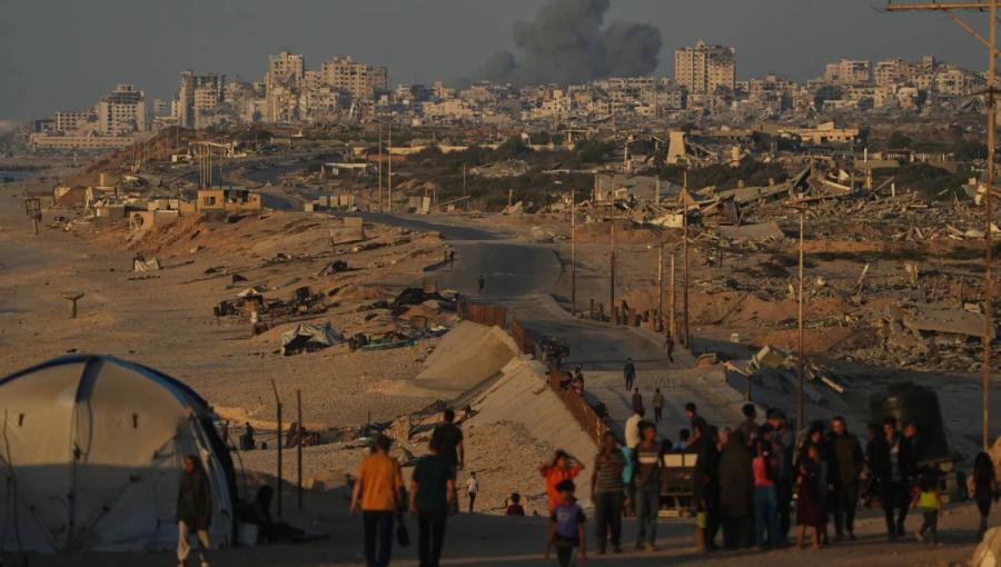 فلسطينيون يسيرون على طول الطريق الساحلي وفي الخلفية دخان يتصاعد إلى السماء بعد غارة شنها الاحتلال على مدينة غزة فلسطينيون يسيرون على طول الطريق الساحلي وفي الخلفية دخان يتصاعد إلى السماء بعد غارة شنها الاحتلال على مدينة غزة | أسوشييتد برس
