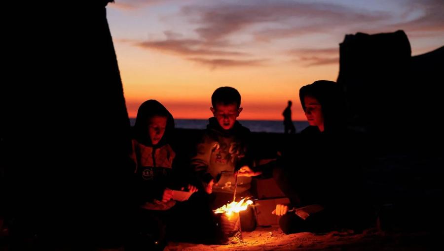 أطفال فلسطينيون يتحلقون حول النار طلبا للدفء وسط قطاع غزة 17/11/2025 | المصدر: رويترز