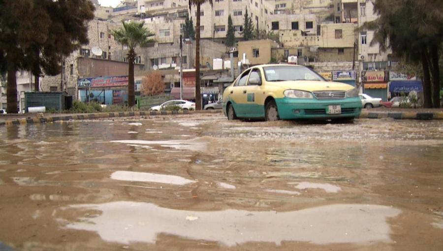 تكسي أصفر يقف بينما تغمر مياه الأمطار أحد شوارع العاصمة عمان | أرشيفية