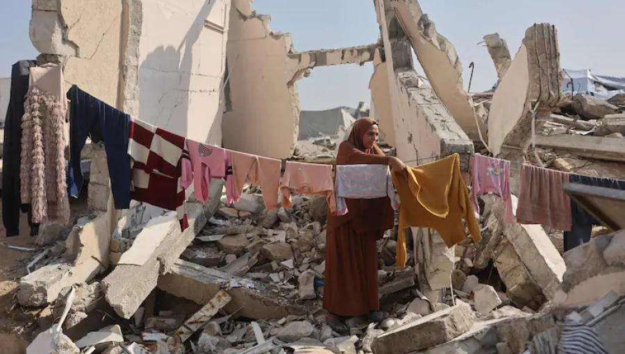 سيدة فلسطينية تقف وسط أنقاض منزل مدمر في غزة تنشر ملابس على حبل غسيل يمتد بين الركام 18/11/2025 | وكالة الأنباء الفرنسية