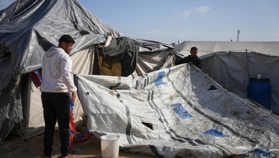 فلسطينيان يحاولان إعادة تركيب جزء من خيمة تضررت جراء الأمطار على الشاطئ بدير البلح 15/11/2025 | أسوشييتد برس