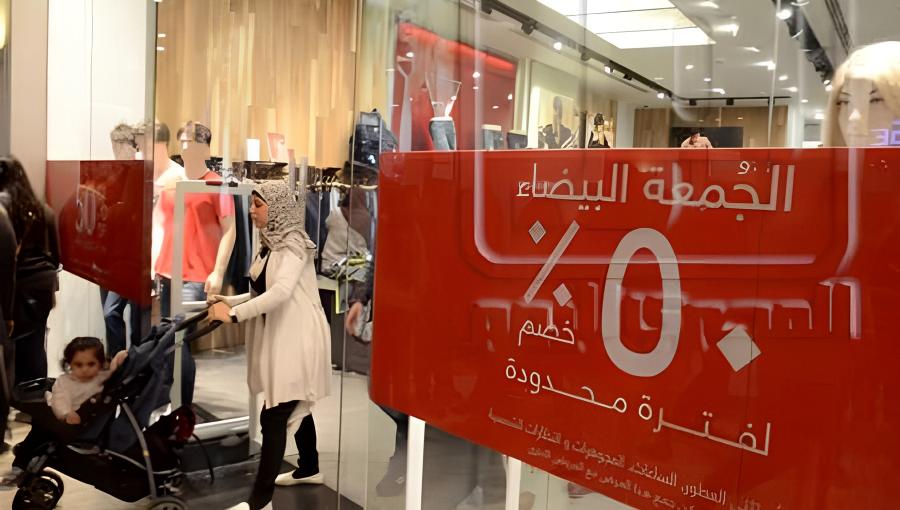 واجهة متجر ملابس مع لافتة تعلن عن خصم بمناسبة الجمعة البيضاء | تعبيرية