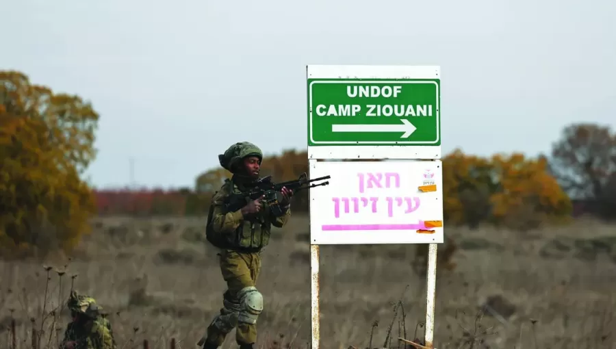 جنديان من جيش الاحتلال الإسرائيلي بجانب إشارة في موقع تابع لمراقبي الأمم المتحدة قرب معبر القنيطرة في الجولان | الوكالة الأوروبية للصور الصحفية