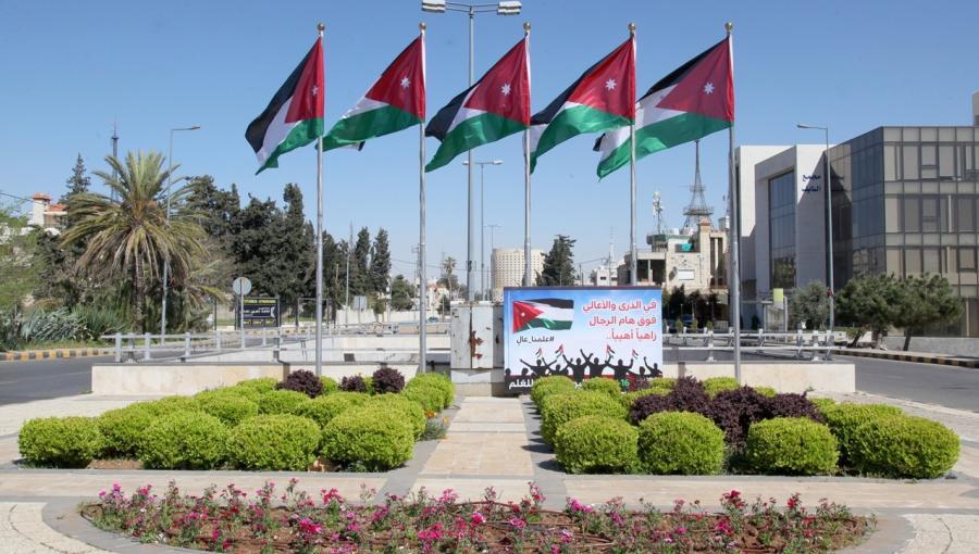 ساحة عامة تتوسطها أعلام الأردن مرفوعة على سوار
