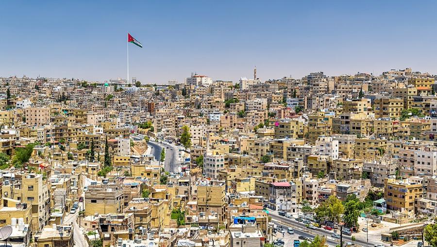 مدينة عمّان يتوسطها علم الأردن