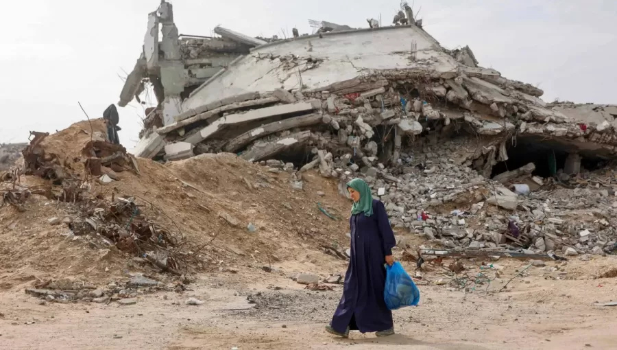 فلسطينية نازحة تمر أمام مبنى مدمر في حي تل الهوى جنوب مدينة غزة 29/11/2025 | وكالة الأنباء الفرنسية