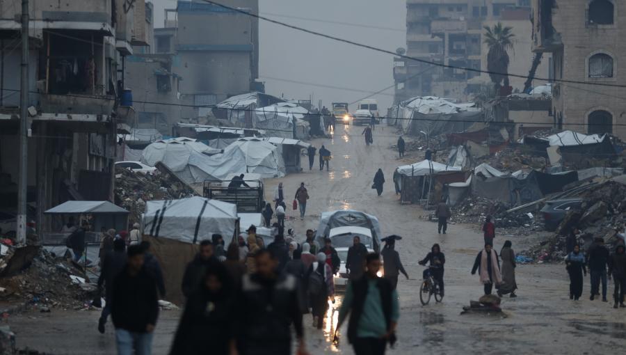 فلسطينيون يسيرون تحت المطر في ظروف إنسانية قاسية تعكس آثار حرب الإبادة الإسرائيلية على غزة