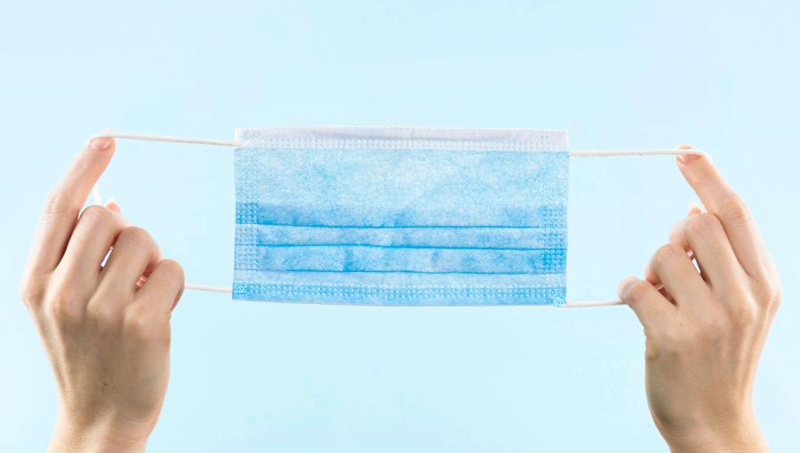 شخص يمسك قناع طبي | تعبيرية freepik