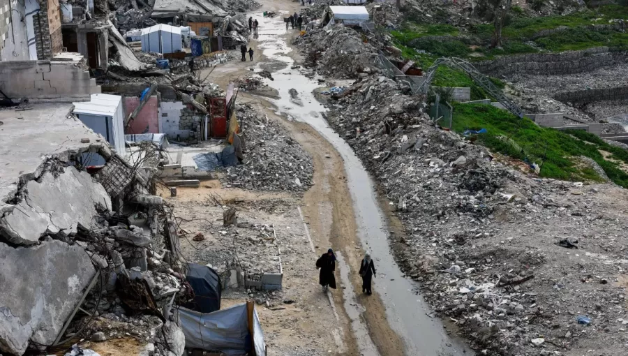 فلسطينيون يسيرون بين أنقاض المباني السكنية التي دمرتها حرب الإبادة الإسرائيلية في مدينة غزة 28/1/2026 | رويترز