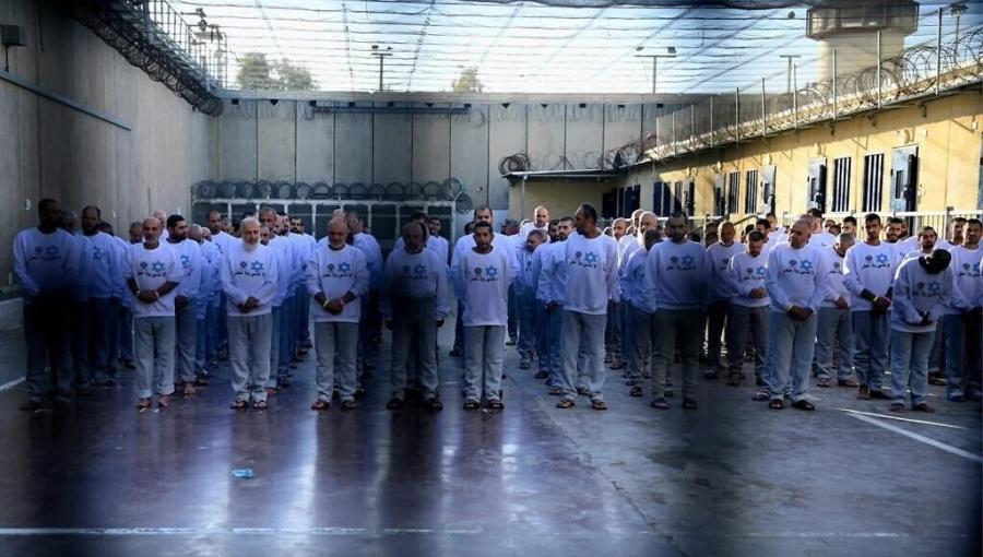 أسرى فلسطينيون داخل أحد سجون الاحتلال الإسرائيلي يرتدون قمصانا كتب عليها "لا ننسى ولا نغفر"