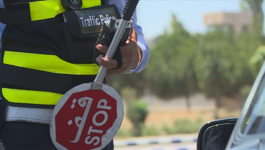 رجل سير يحمل شاخصة قف في أحد شوارع العاصمة عمان