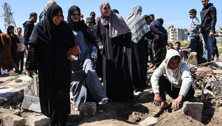 فلسطينيون حول قبر شهيدين من أقاربهم استهدفتهما غارة إسرائيلية في حي الشجاعية بمدينة غزة 28/3/2026 | وكالة الأنباء الفرنسية