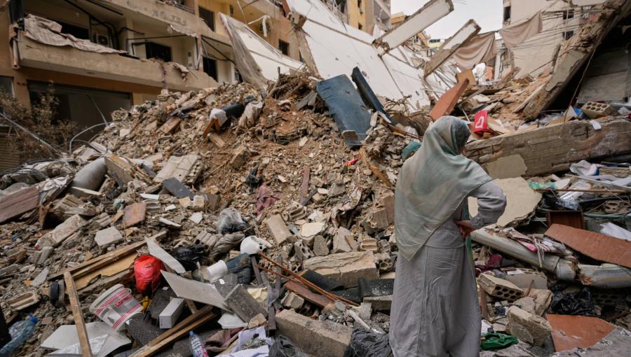 سيدة تقف أمام مبنى مدمر في الضاحية الجنوبية لبيروت | أسوشييتد برس