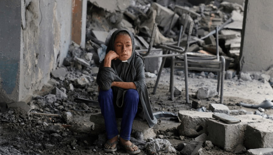فتاة فلسطينية تجلس وسط الأنقاض في مدرسة تابعة للأمم المتحدة حيث كان النازحون يحتمون، بعد أن قصفها جيش الاحتلال في حي الزيتون بمدينة غزة | رويترز