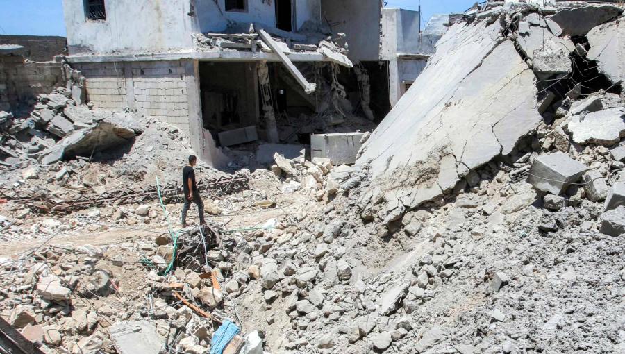 رجل يسير بين أنقاض مبنى مدمر في قرية دير قانون النهر جنوب لبنان | وكالة الأنباء الفرنسية