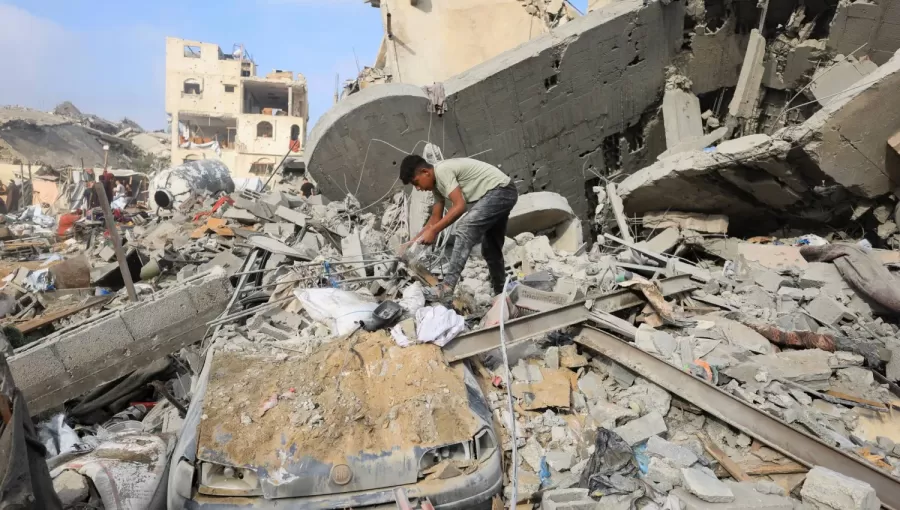 طفل فلسطيني يتفقد موقع الغارة الإسرائيلية التي استهدفت مدينة غزة | رويترز