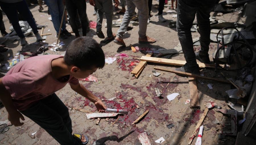 طفل فلسطيني يتفقد موقع غارة عسكرية إسرائيلية في دير البلح وسط غزة | أسوشييتد برس