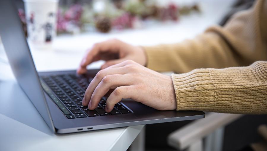 صورة تعبيرية لشخص يستخدم حاسوب محمول