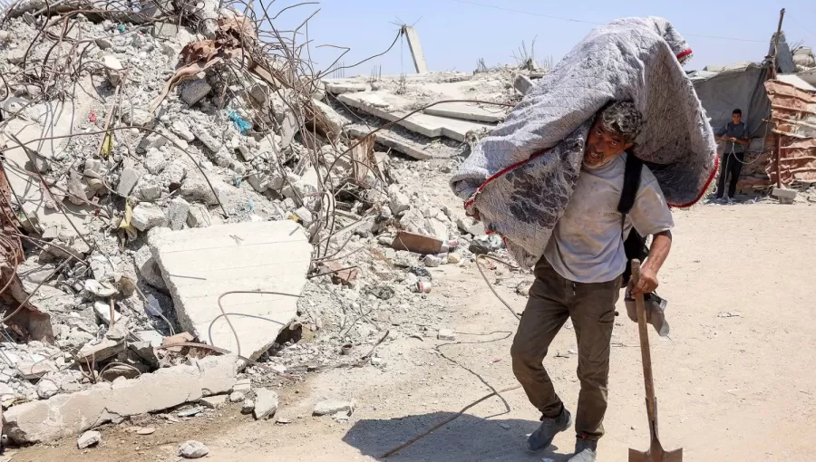 فلسطيني يسير بجانب الأنقاض في مخيم للنازحين بغزة | وكالة الأنباء الفرنسية