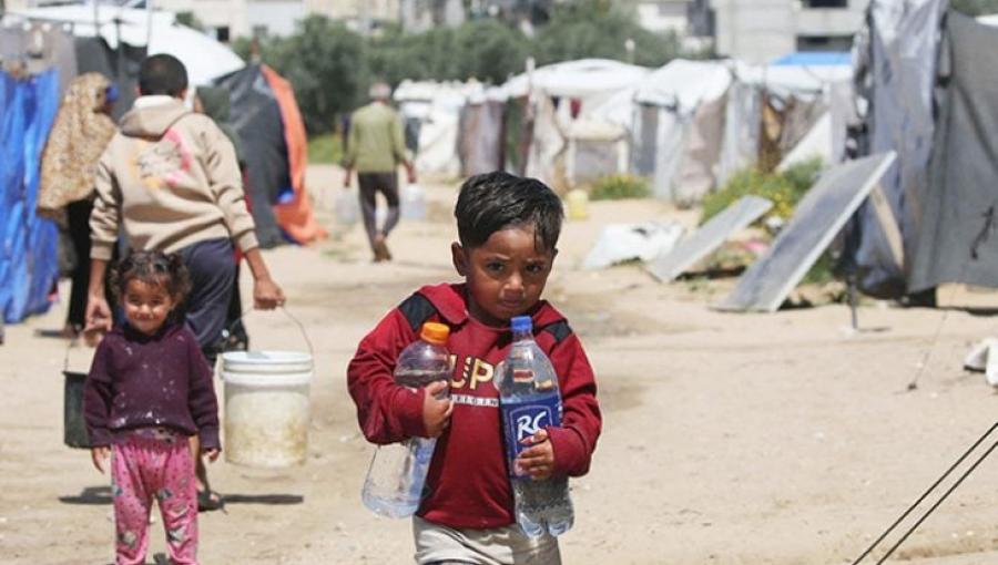 طفل ينقل المياه بعبوات في مخيم البريج | القدس العربي