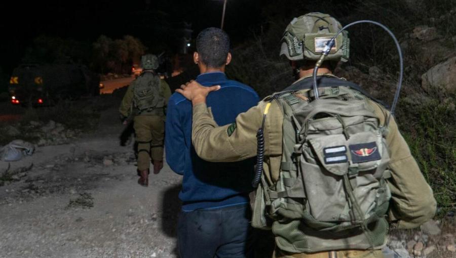 جندي من جيش الاحتلال يقتاد فلسطينيا لاعتقاله