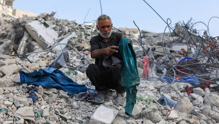 فلسطيني يبحث بين أنقاض مبنى سكني انهار بعد تضرره في قصف إسرائيلي سابق بمدينة غزة | أرشيفية رويترز