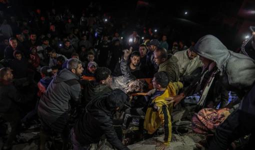 فلسطيني يرفع شارة النصر بعيد إخراجه من تحت أنقاض المبنى الذي دمرته غارة إسرائيلية على دير البلح 22/12/2023