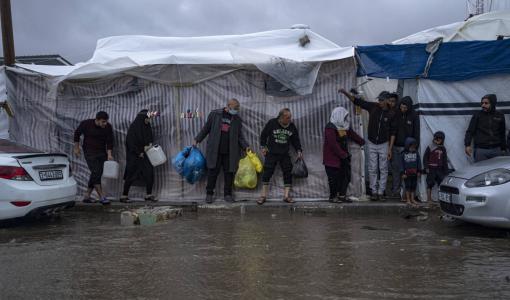 فلسطينيون نازحون يحاولون الاحتماء من الأمطار في مدينة خانيونس جنوب قطاع غزة 19/11/2023 | المصدر: أسوشييتد برس