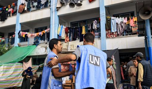 عاملان في وكالة الأونروا في إحدى المدارس التابعة للوكالة والتي تؤوي نازحين في غزة | المصدر: وكالة الأنباء الفرنسية