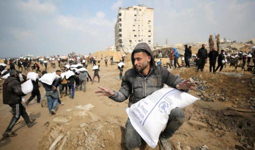 رجل فلسطيني من غزة يحصل على كيس طحين وسط المجاعة التي يعيشها القطاع | المصدر: الجزيرة