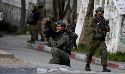 أحد أفراد شرطة الاحتلال يشير بسلاحه صوب فلسطينيين في القدس  | المصدر: الأناضول