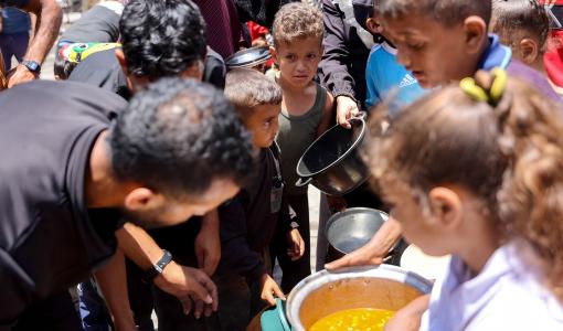 أطفال يصطفون للحصول على الطعام في مدرسة تابعة للأونروا في مخيم جباليا للاجئين الفلسطينيين في شمال قطاع غزة في 17/6/2024 | المصدر: وكالة فرانس برس