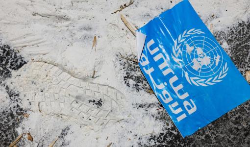 لافتة تحمل شعار الأونروا ملقاة على الأرض