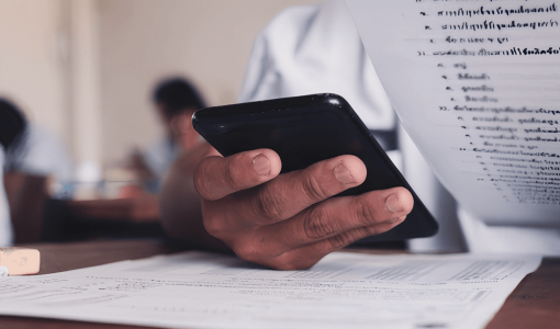 تعبيرية لطالب يمسك هاتف خلال الامتحان | المصدر: shutterstock