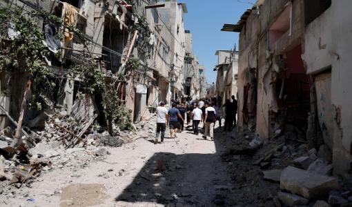 فلسطينيون يسيرون بين الدمار الذي سببته غارة إسرائيلية على طولكرم بالضفة الغربية | المصدر: رويترز