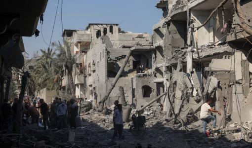 فلسطينيون يتفقدون الدمار في دير البلح وسط قطاع غزة بعد القصف الإسرائيلي 7/8/2024 | المصدر: وكالة الأنباء الفرنسية