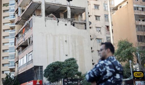 أحد أفراد الأمن يقف بجوار المباني المتضررة في غارة إسرائيلية بمنطقة الكولا وسط بيروت | المصدر: رويترز