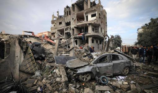 فلسطينيون يتفقدون الأضرار التي لحقت بمخيم المغازي للاجئين بعد غارة إسرائيلية 25/12/2023 | المصدر: وكالة الأنباء الفرنسية