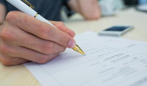 صورة تعبيرية | يد شخص يملأ استمارة | المصدر: freepik