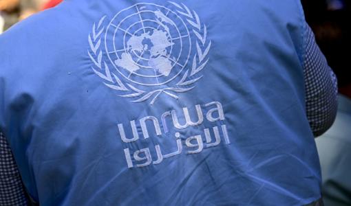 موظف يرتدي شعار وكالة الأونروا